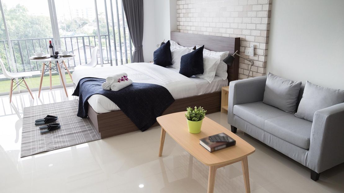 A bedroom that has had a floor to ceiling window installed 